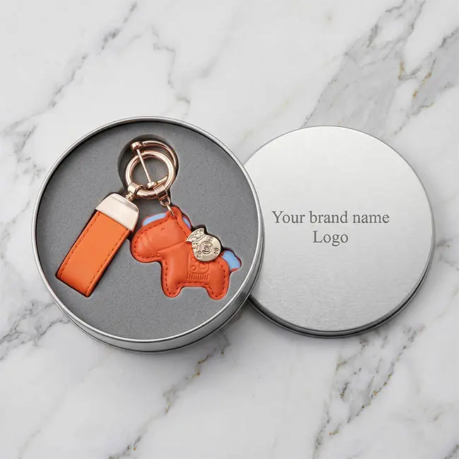 Matte silver tin box fully packed with a custom leather and metal keychain secured perfectly in die-cut EVA foam.