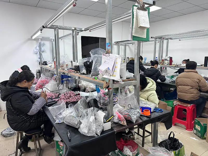 Factory technicians performing manual quality control and precision hand-assembly of custom zinc alloy hardware in a dedicated production room.