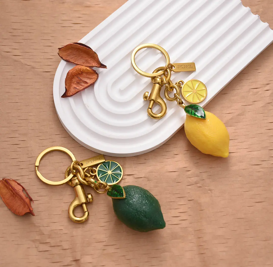 Polished gold zinc alloy keychain with Swarovski-style crystals and leather strap, ready for wholesale shipping.