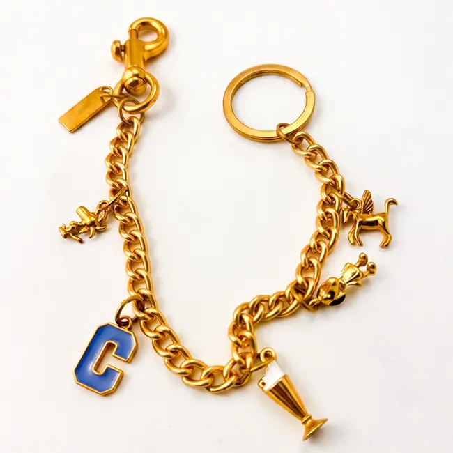Vista principal de cadenas extensoras al por mayor de 305mm en aleacion de zinc oro claro adornadas con letra C mayuscula en esmalte azul y dijes de metal solido