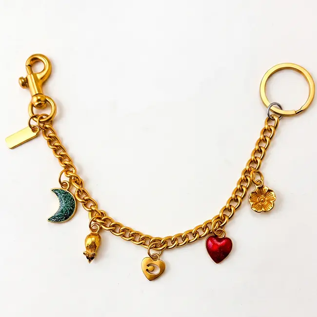Vista principal de cadenas extensoras al por mayor en aleacion de zinc oro claro adornadas con luna esmaltada verde con purpurina corazon de eco-resina roja y dijes metalicos