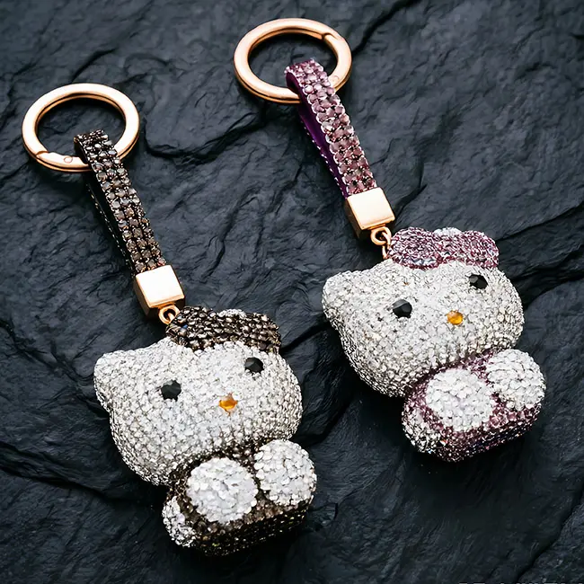 Two factory direct pavé charms featuring full-pavé animal optical rhinestone inlaid cat motif in jet black and dusty mauve highlighting the precise stone setting and robust zinc alloy frame.