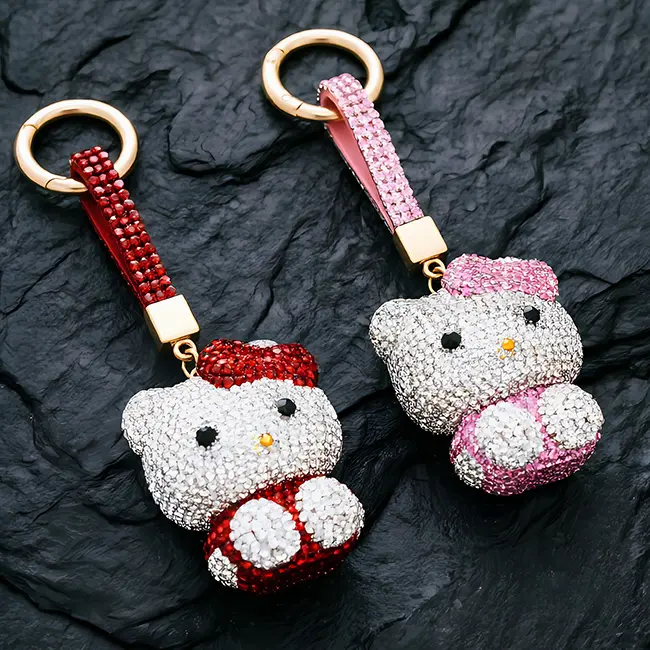 full-pavé animal motif ruby red and soft pink cat charms of factory direct pavé charms featuring full body optical rhinestone inlaid with matching crystal studded straps and gold hardware on a slate background.