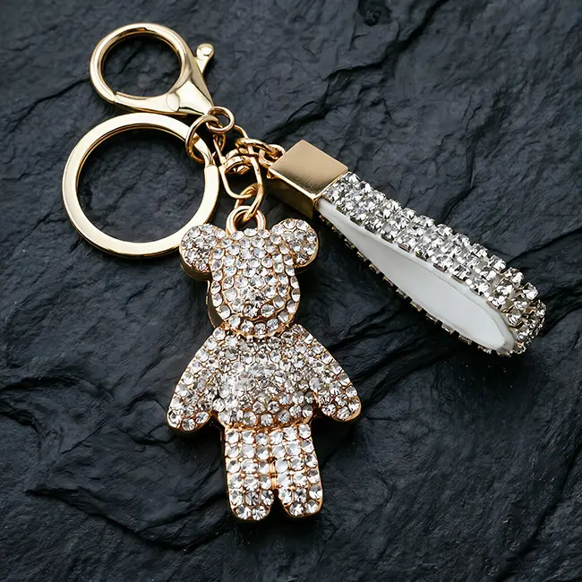 A stunning light metallic gold factory direct pavé charms accessory highlighting a crystal clear optical rhinestone bear with a matching studded strap and robust zinc alloy clasp on a slate.