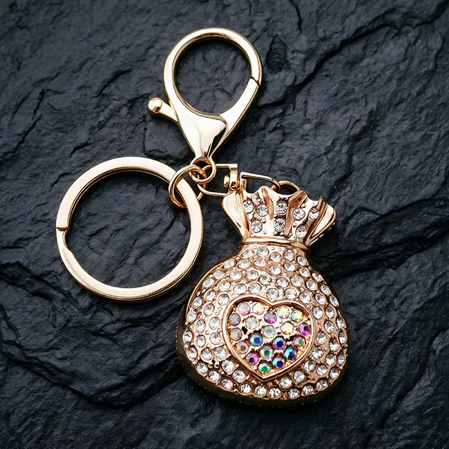 A hardware assembly close up view of the B2B optical crystal molding accessory showcasing the brilliant iridescent clear rhinestone heart on the gold fortune bag and heavy duty zinc alloy clasp.