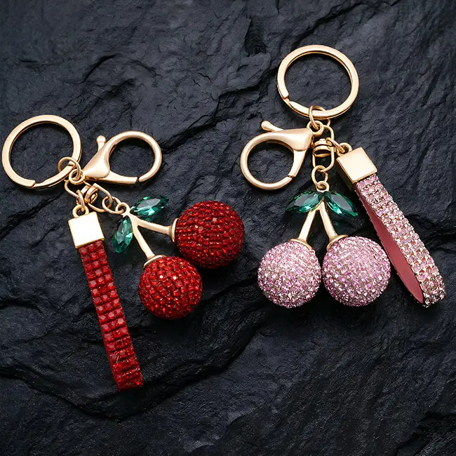 A pair of premium light gold factory direct pavé charms featuring ruby red and soft pink optical rhinestone cherries with eco-resin emerald green leaves, a heavy-duty clasp, and matching crystal straps.