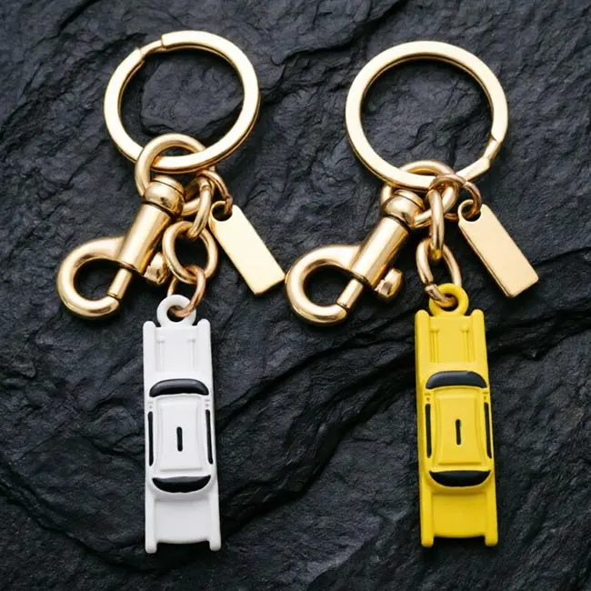 Two options of the bulk 3D moulded enamel infill charms taxi keyring showcasing classic yellow and crisp white cab colours - featuring high-grade zinc alloy construction and durable gold electroplated hardware.