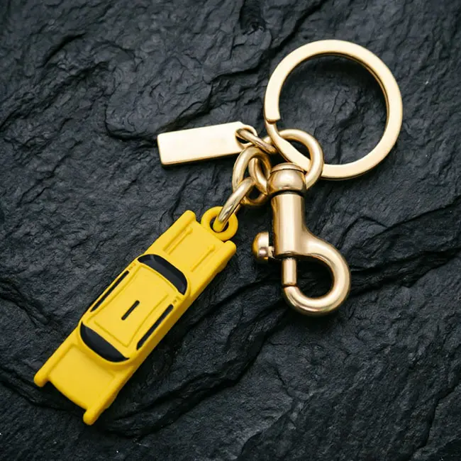 A premium bulk 3D moulded enamel infill charms taxi component featuring a solid yellow zinc alloy cab charm - black window accents - a gold spring snap hook - and a blank custom logo tag on slate.