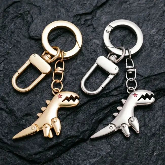 Two options of the dinosaur wholesale Precision Zinc Alloy Castings keyring showcasing radiant gold and sleek silver colours - featuring high-grade solid construction and electroplated durable hardware.