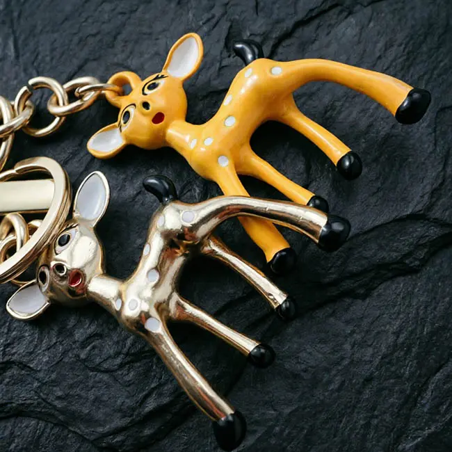 A macro material detail view of the Sika deer Precision Zinc Alloy 3D moulded charms showcasing the handicraft enamel infill white spots painted eyes and robust metallic structural bodies