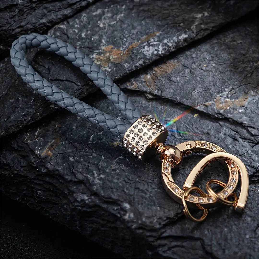 VIP boutique fusion accessory featuring a premium woven braided microfiber leather cord, securely clamped by custom gold-plated zinc alloy hardware with high-density optical rhinestone pave integrations.